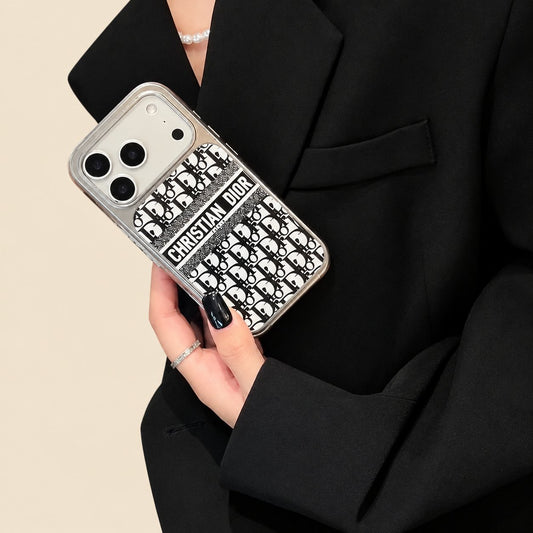 Black Christian Dior monogram design iPhone case held against a black outfit, showing a contrasting name band and silver-coloured trim.