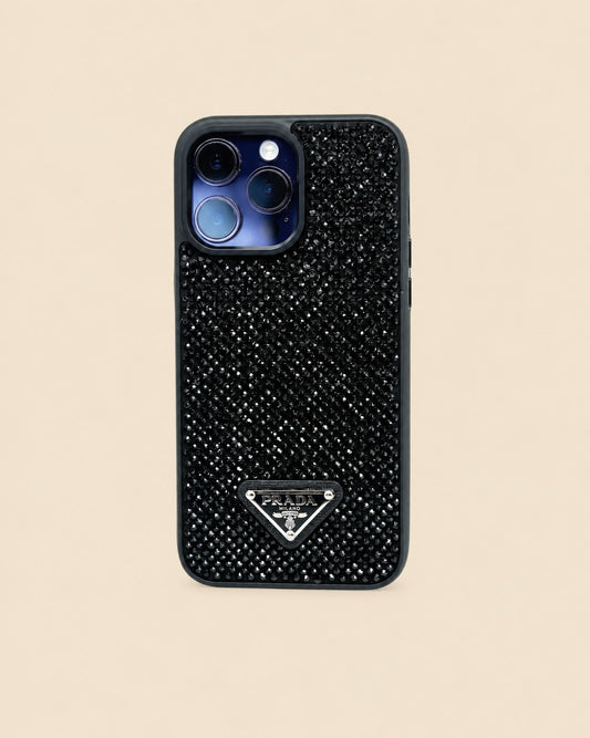 Black Prada triangle design iPhone case with dark faceted studs, dark trim and a blue-toned display phone camera.