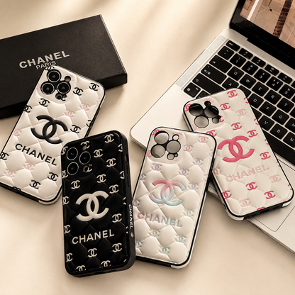 Chanel phone cases on a desk with a laptop