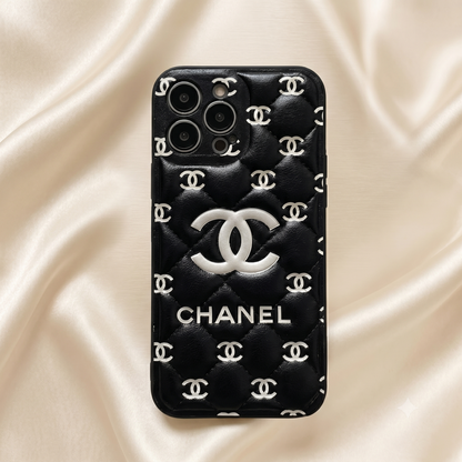 Black Chanel phone case with logo on a beige fabric background