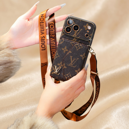 Louis Vuitton iphone case with strap held by a hand on a beige background