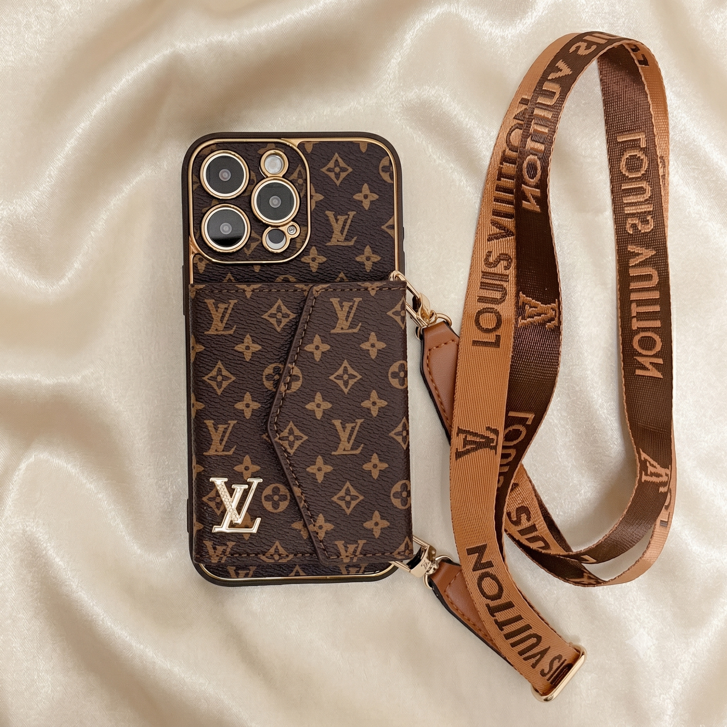 Louis Vuitton phone case with monogram pattern and matching strap on a beige fabric background