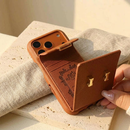 Brown iPhone case with the rear card pocket flap open, held over cream travertine and linen.