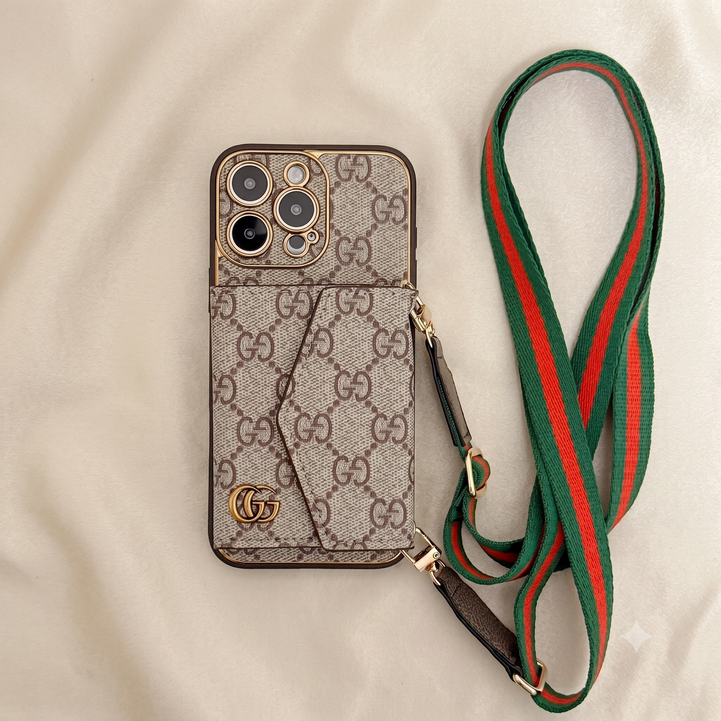 iPhone case with Gucci logo and matching green and red strap on a beige background