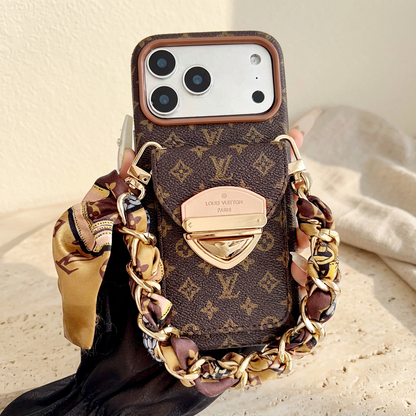 Brown small-motif monogram rear-pocket case held upright with a gold-tone clasp and brown-and-gold scarf woven through a short chain.