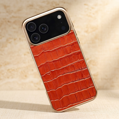 Left-tilted orange-brown croc-pattern iPhone case with gold-tone edging and a black camera area.