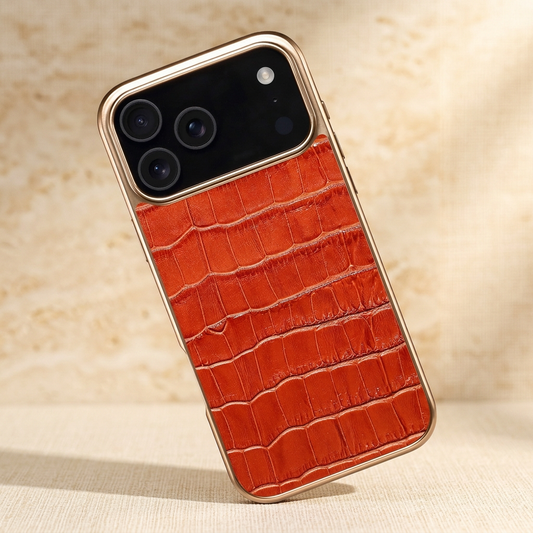 Left-tilted orange-brown croc-pattern iPhone case with gold-tone edging and a black camera area.
