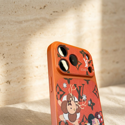 Close-up of the orange festive Louis Vuitton monogram design case showing the patterned camera panel, three large lenses and upper rear character print.