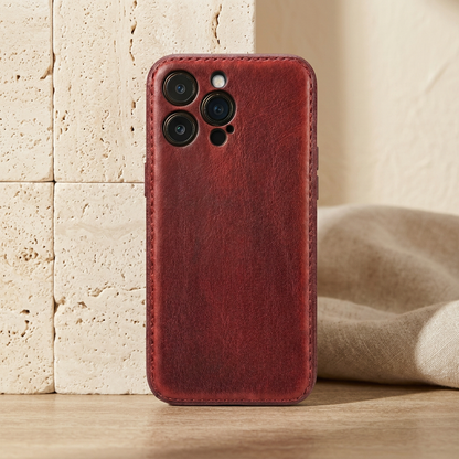 Red vintage-grain case fitted on a display phone, showing stitched edging and individual camera openings.