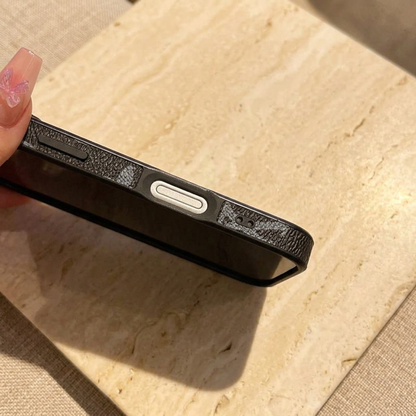 Tight side-edge close-up showing the black textured case, a silver-tone elongated control, a black button and a small paired-hole opening.