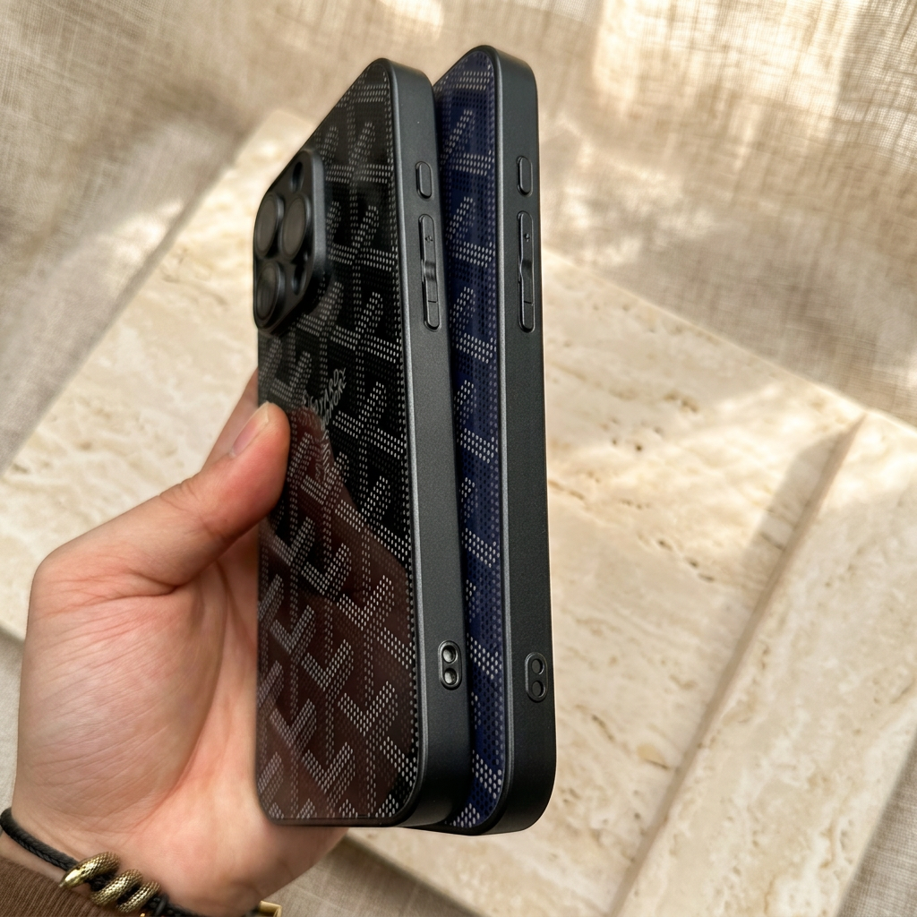 Black and navy blue cases held at a side angle, showing dark flat rims, shaped controls and small paired-hole openings near the lower edges.