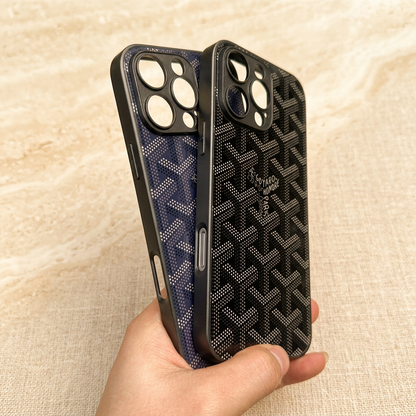 Black chevron case held in front of a navy blue case, showing dotted patterns, central name details and empty circular camera openings.