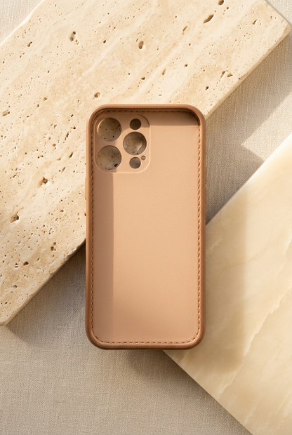 Empty tan iPhone case viewed from inside, showing its smooth inner panel, stitched edge and open camera holes.