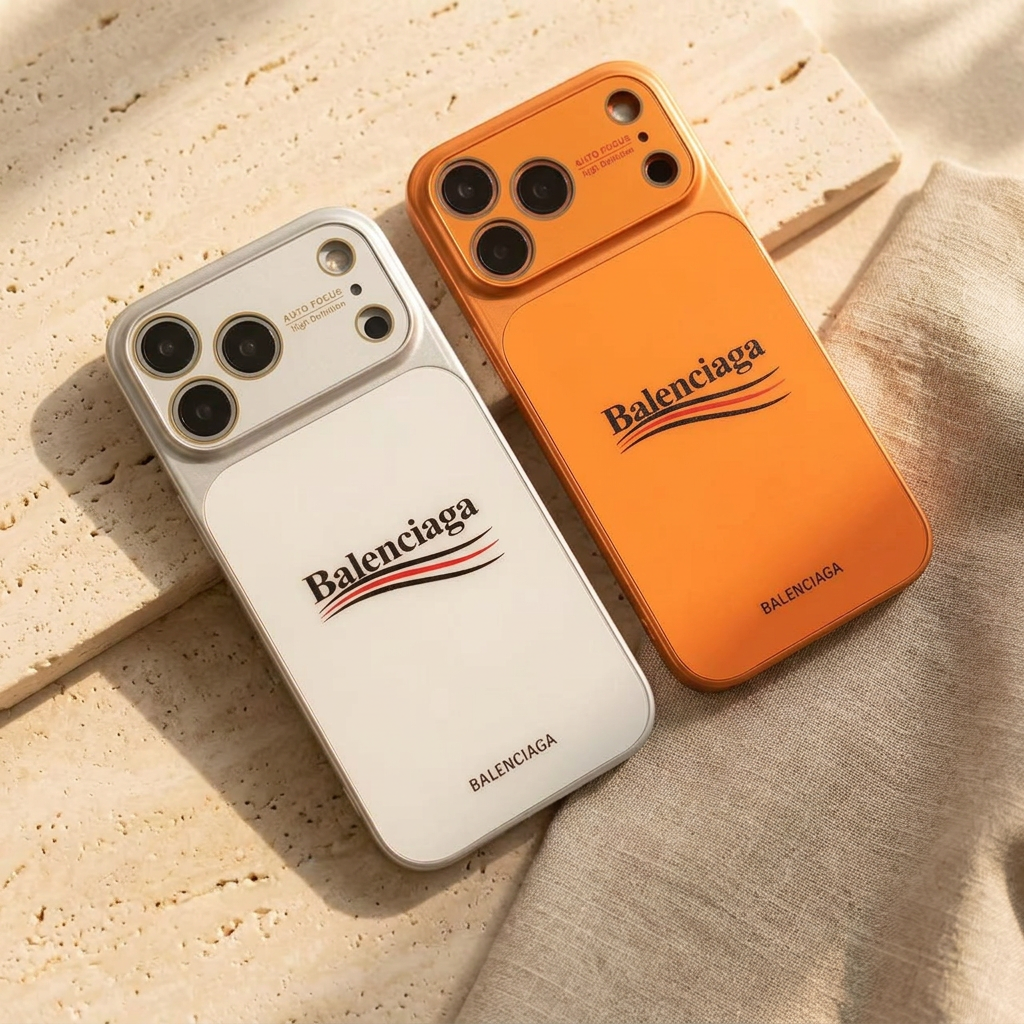 Silver-toned White and orange back covers lying diagonally side by side, showing their wordmark designs and colour-matched camera surrounds.