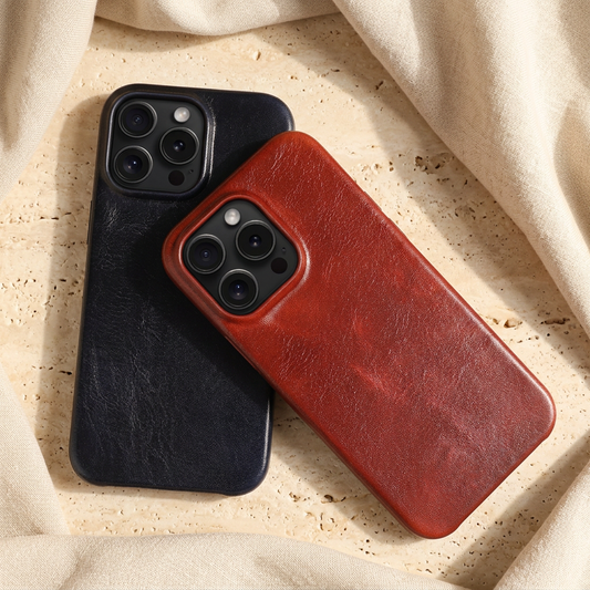 Red creased-grain iPhone back cover angled across a black case, with both fitted phones’ camera areas visible.