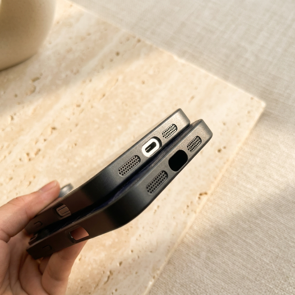 Tight view of two case bottoms showing differently shaped charging-port openings between paired perforated sections.