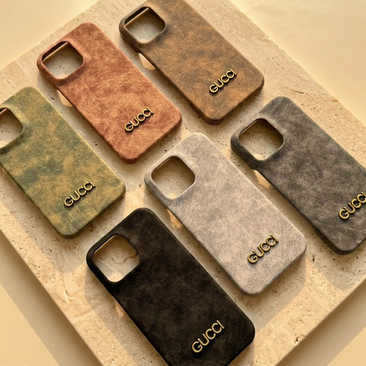 Six mottled Gucci name design iPhone back covers in black, gray, white, peach pink, olive green and khaki brown with empty square camera openings.