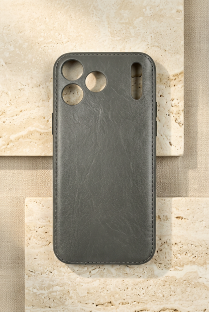 Grey stitched empty rear shell with creased grain, three round camera openings and a tall narrow slot.