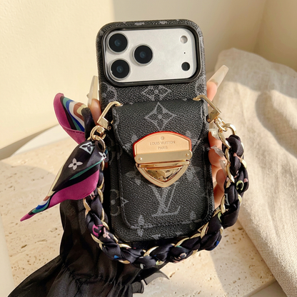Hand-held tonal black monogram case with a gold-tone rear-pocket clasp, black scarf-woven chain and multicoloured tied scarf end.