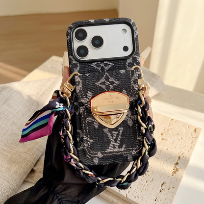 Hand-held black woven-look monogram case with a rear clasp pocket and black scarf-woven short chain, preserving the sheer sleeve and long decorated nails.