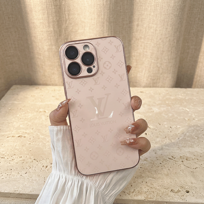 Pale Pink Louis Vuitton monogram design iPhone case held in a white-sleeved hand, showing faint tonal motifs, a large central LV detail and rose-toned trim.