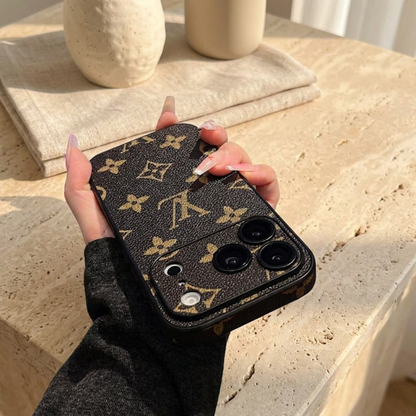 Tilted rear view of the dark textured case showing large gold LV and floral motifs and the matching patterned camera surround.